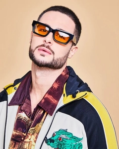 Close-up of rectangular sunglasses with thick black frames and orange tinted lenses