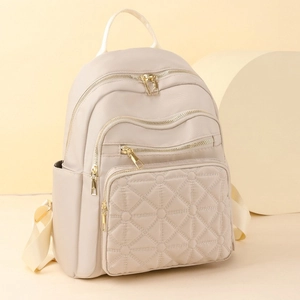 Chic beige quilted nylon backpack for women featuring multiple gold zippers and star stitching