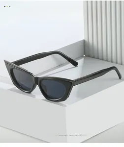 Detail of black cat eye sunglasses with dark UV400 lenses on white geometric stand