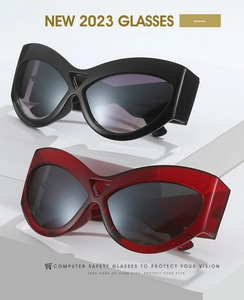 Detail of oversized cat-eye sunglasses with hollow bridge in black and translucent red
