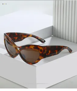 Detail of tortoise shell cat eye sunglasses with dark brown lenses on geometric stand
