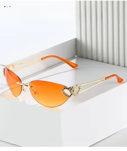 Detail of rimless cat-eye sunglasses with orange gradient lenses and gold heart decor