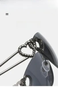 Macro detail of sunglasses arm with interlocking double heart metal decoration