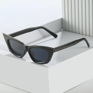 Classic black cat-eye sunglasses with dark lenses on a minimalist geometric pedestal