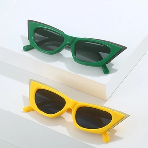 Green and yellow cat-eye sunglasses with thick geometric frames and dark lenses