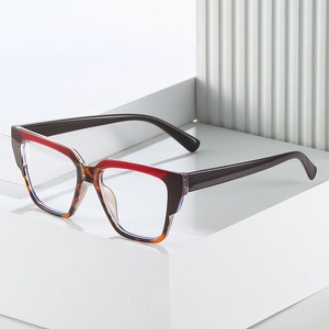 Modern TR90 square eyewear frame with red and tortoiseshell color-block design on white stand