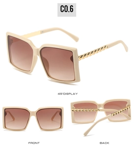 Detailansicht der eckigen Sonnenbrille mit cremefarbenem Rahmen und Goldkette