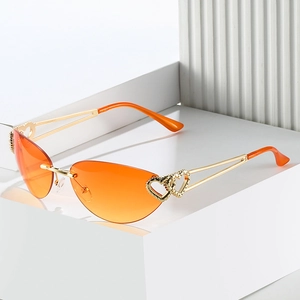 Frameless cat-eye sunglasses with orange gradient lenses and golden double heart metal frames