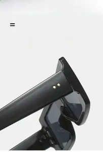 Detailed view of black oversized square sunglasses featuring elegant gold rivet accents