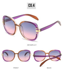 Detail view of oval sunglasses featuring purple-orange gradient lenses and golden hinge accents