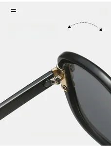 Close-up of a durable golden metal hinge on black oval sunglasses frame