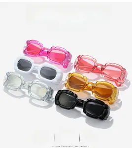Détail de lunettes de soleil Y2K multicolores aux montures ondulées roses et ambre