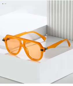 Détail de lunettes aviateur orange avec monture transparente et charnières métalliques