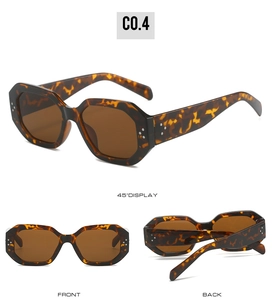 Detail view of tortoiseshell geometric sunglasses with silver rivets and dark brown lenses