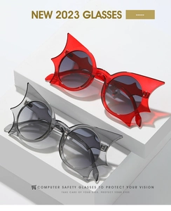 Close-up of stylish bat-shaped butterfly sunglasses in transparent red and grey frames