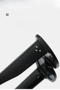Close-up of lightweight black sunglasses featuring silver metal rivets on wide temples