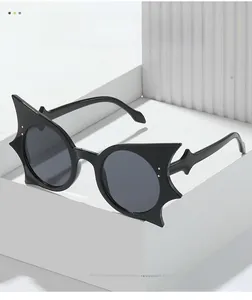 Detail of bat-shaped black sunglasses featuring unique wave-shaped temples on white stand