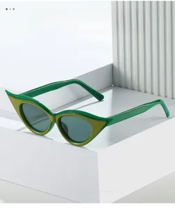Detail of retro cat-eye sunglasses with green color-blocking on geometric white stand