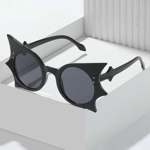 Unique bat wing style sunglasses with black pointed frames and dark round lenses