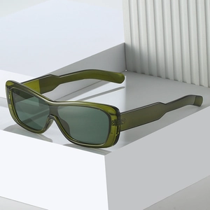 Lunettes de soleil carrées vert émeraude translucides sur fond décoratif géométrique