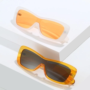 Lunettes de soleil monobloc chic à monture étroite en blanc mat et ambre sur socle blanc
