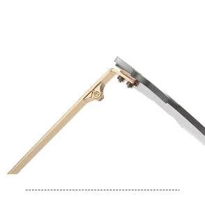 Detail of the golden metal hinge and screw assembly on rimless sunglasses