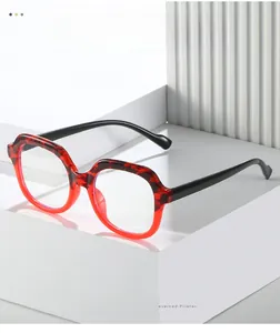 Detail of red and black gradient square glasses frame with polished finish on display