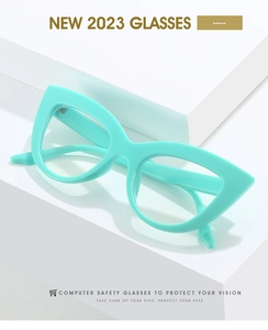 Detail of mint green cat eye eyeglass frames on a minimalist white geometric stand