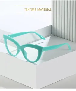 Detail of mint green cat-eye eyeglass frame displayed on a white geometric platform