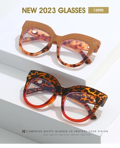 Close-up of tortoise shell cat eye frames featuring silver rivet details on a white stand