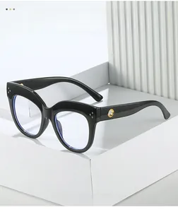 Detail of black cat-eye frames with golden hollow ring accents and blue light lenses