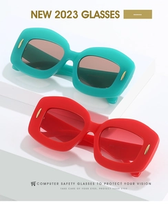 Detail of oval jelly sunglasses with gold pin accents in teal and red frames