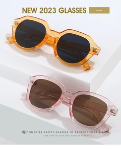 Détail de lunettes de soleil ambre et rose sur un support géométrique moderne blanc