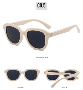 Détails de lunettes de soleil vintage crème avec verres noirs et rivets ovales argentés