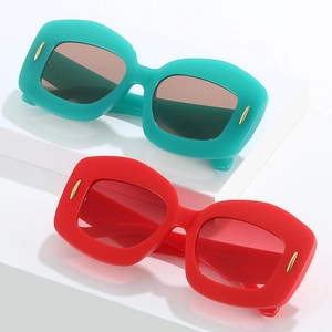 Oval oversized sunglasses with thick frames and gold pin accents in red and teal