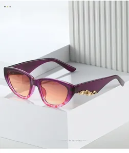 Detailed side view of purple cat eye sunglasses with golden wave-shaped metal accents