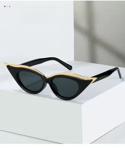 Détail de lunettes œil de chat vintage avec décor en métal doré sur monture noire brillante