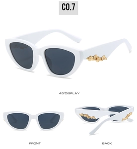 Close-up of cat-eye sunglasses with white frame and gold filigree temple details