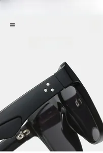 Detail of black sunglasses frame with silver star rivets and premium metal hinges