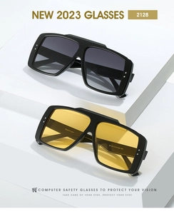 Detail view of bold square sunglasses showing gradient gray and bright yellow lenses