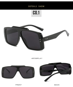 Detail view of black oversized square sunglasses with metal rivets and dark grey lenses