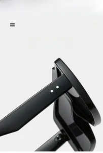 Macro detail of black acetate sunglasses frame featuring signature double dot metal rivets