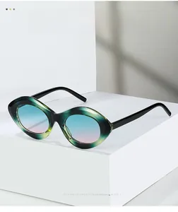 Détail de lunettes de soleil œil-de-chat avec monture dégradé vert et verres dégradé rose