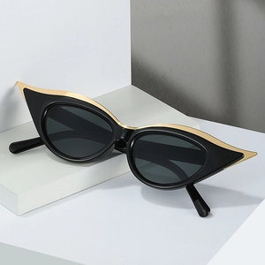 Lunettes de soleil œil de chat vintage avec décor en métal doré sur socle moderne