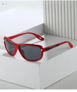 Close-up of red sports sunglasses with gray lenses on a white geometric platform