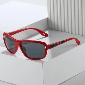 Sporty red frame sunglasses with dark lenses displayed on modern white geometric props
