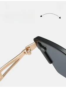 Detail of durable gold metal hinges on retro cat-eye sunglasses with black frames