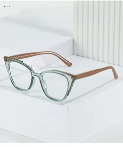 Detail of cat eye glasses frame with transparent green front and brown temples on white blocks