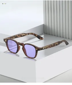Detail of tortoise frame sunglasses with purple lenses and gold metal rivets