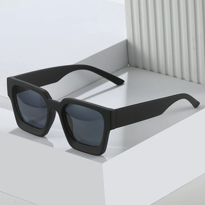 Classic square matte black sunglasses with dark lenses on a minimalist display stand